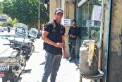 جمشید قدرتی با کلمن جلوی مغازه‌اش، رهگذران را سیراب می‌کند